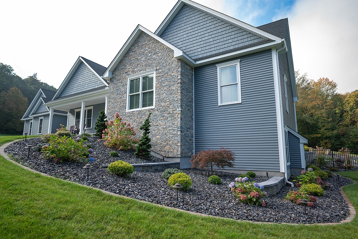 Worker spraying pesticide onto green lawn outdoors, closeup. Pest control